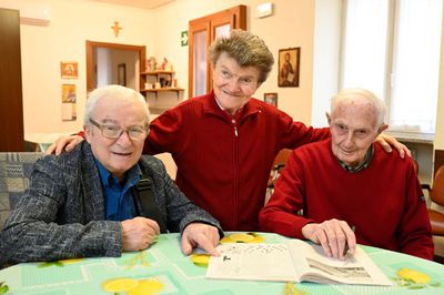 Tre persone sorridono alla telecamera.